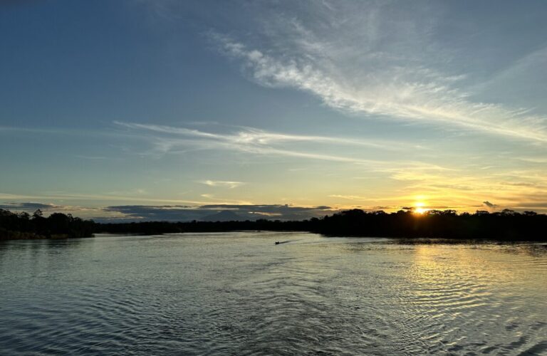 A sunset on a body of water in the Amazon rainforest.