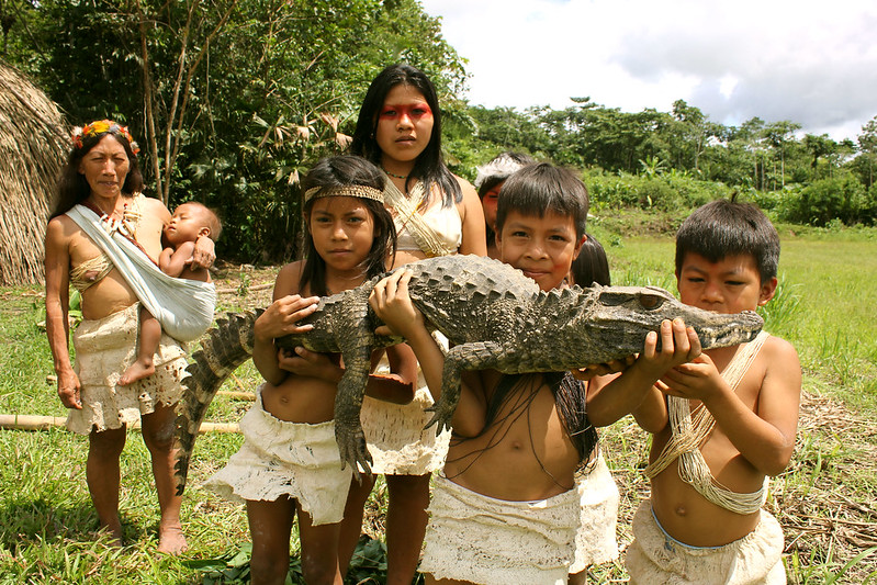 Amazonian kids holding a crocodile